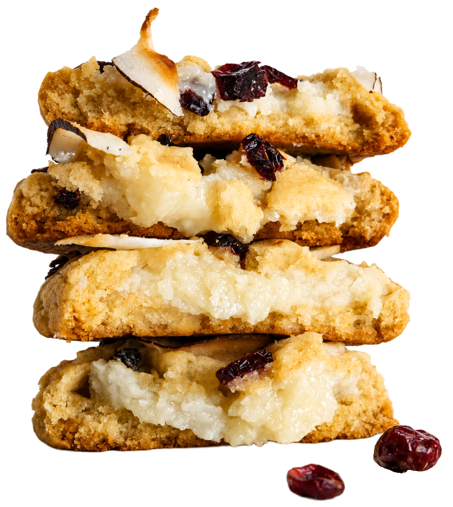Four stacked sliced cookies with a creamy white filling, toasted coconut flakes, and dark red dried cranberries, isolated on a white background with two cranberries placed in front.